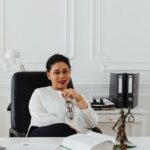 Professional woman sitting at desk in a stylish office, exuding confidence and leadership.